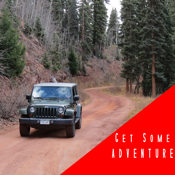 a red truck driving down a dirt road