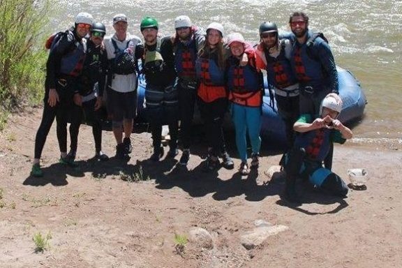 a group of people standing next to a body of water