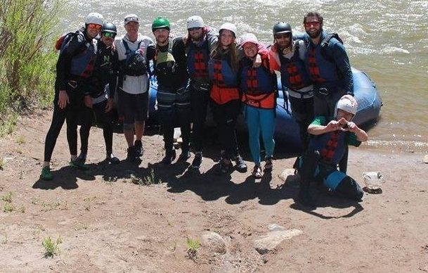 a group of people standing next to a body of water