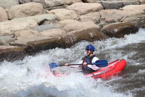 a man in a wet suit on a raft in a body of water