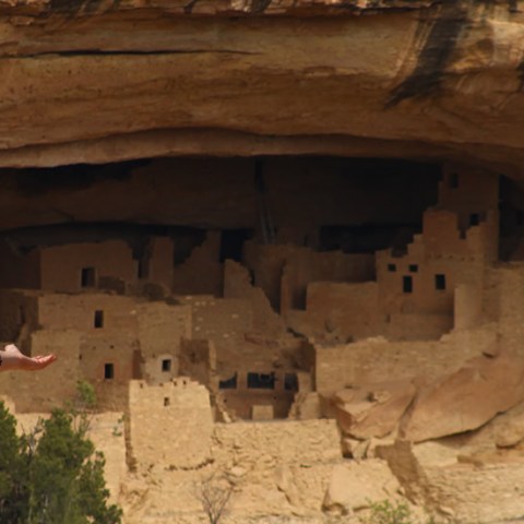 a person standing in front of a large rock